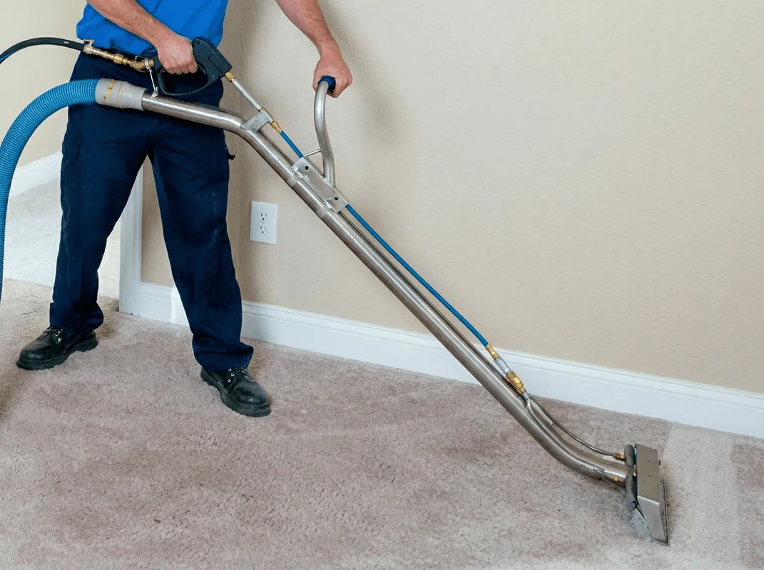 Professional operating a liquid removal machine on a carpeted floor in Nashua, NH